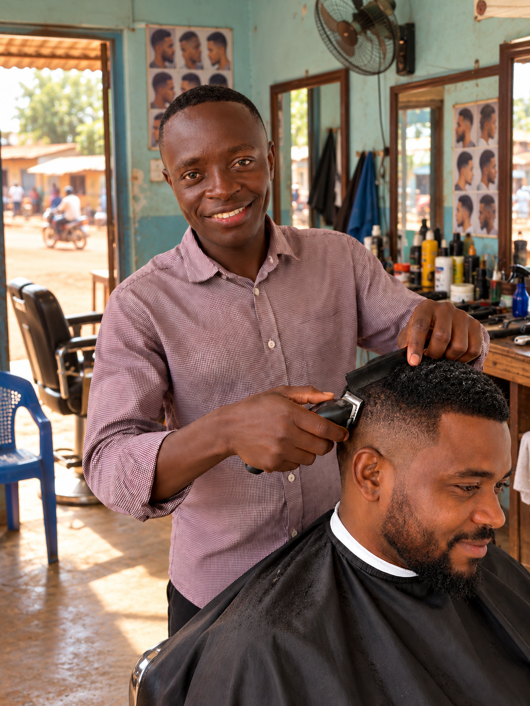 Calvin en train de couper les cheveux d’un client dans son salon à Bangui